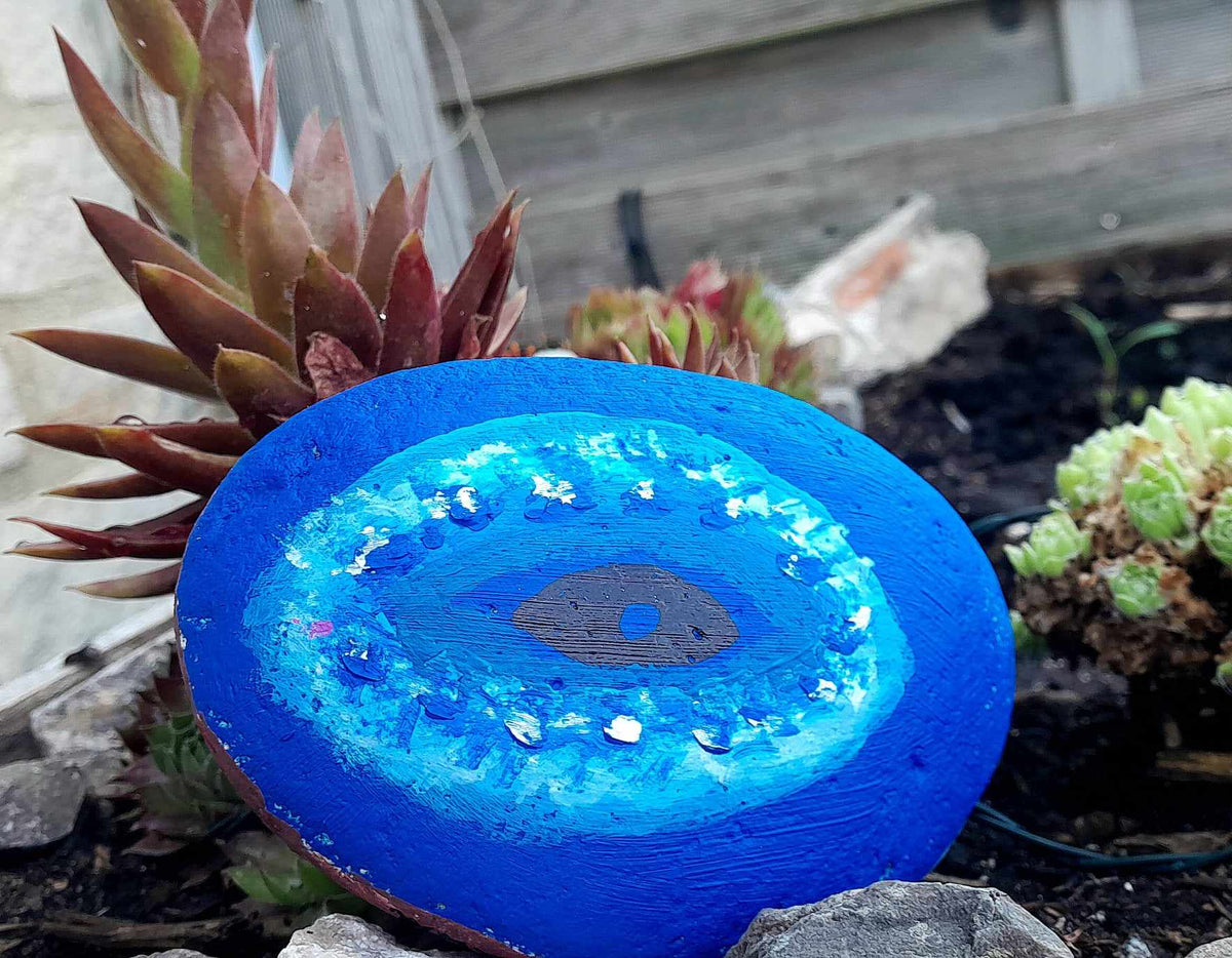 Greek painted pebble, ,with vivid blue colours, symbolizing the Greek blue sea and sky